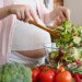 Iron deficiency affects an estimated 40 per cent of pregnant women. Image: Adobe. A pregnant woman makes a healthy salad.